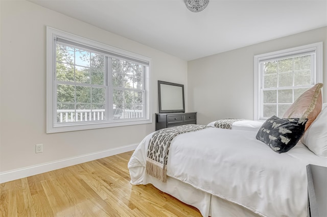 bedroom with wood finished floors and baseboards