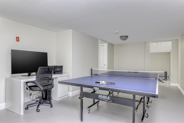 game room featuring concrete flooring and baseboards