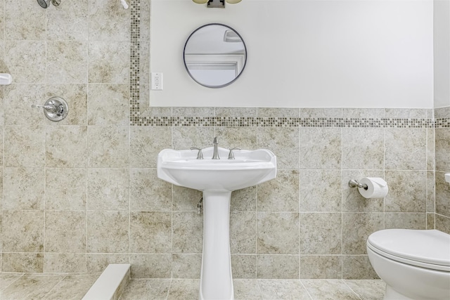 bathroom with tile walls and toilet