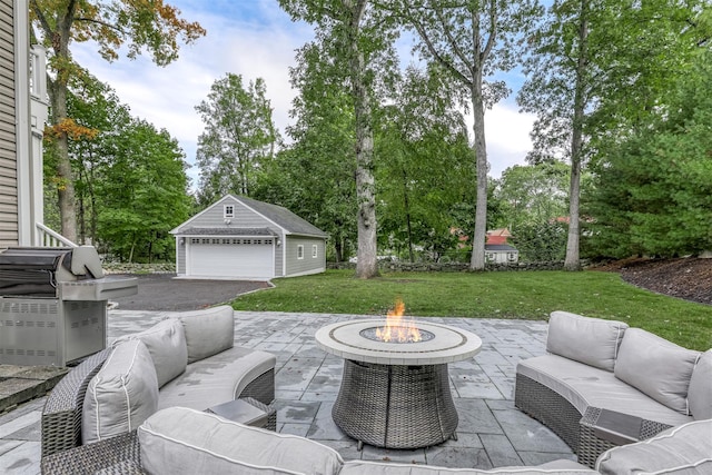 view of patio with a garage, an outdoor living space with a fire pit, and an outbuilding