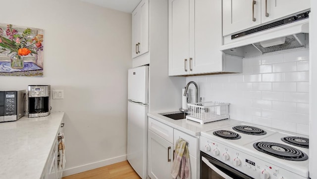 kitchen with white cabinetry, decorative backsplash, white appliances, light countertops, and under cabinet range hood