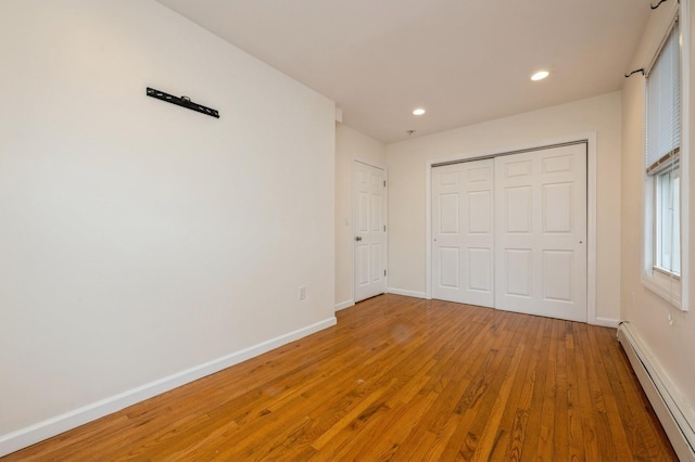 3 September Walk, Long Beach, NY 11561 - unfurnished bedroom with baseboard heating, wood finished floors, baseboards, recessed lighting, and a closet