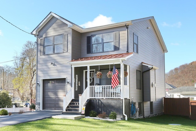 traditional home featuring an attached garage, driveway, covered porch, and fence