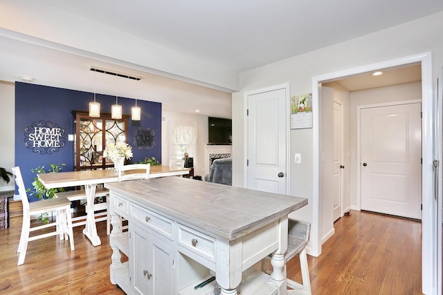 dining space with light wood finished floors, a fireplace, and recessed lighting