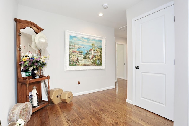 hallway with baseboards, recessed lighting, and wood finished floors