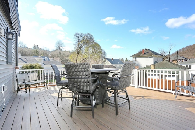 wooden terrace featuring outdoor dining area and a residential view