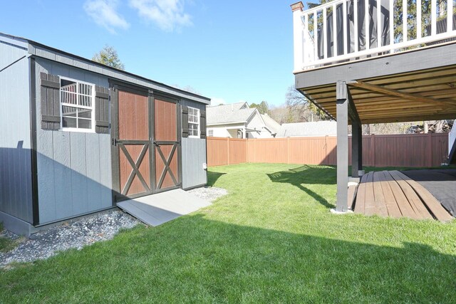 view of yard featuring a storage shed, an outdoor structure, and fence