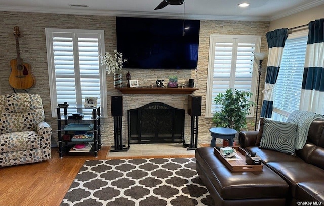 60 Erin Ln Unit 60, East Setauket, NY 11733 - living area featuring wood finished floors, healthy amount of natural light, ornamental molding, ceiling fan, and a stone fireplace