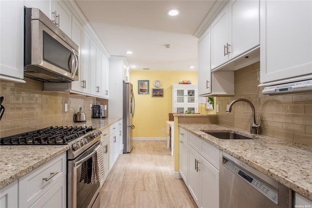 60 Erin Ln Unit 60, East Setauket, NY 11733 - kitchen with appliances with stainless steel finishes, white cabinets, backsplash, recessed lighting, and light stone counters
