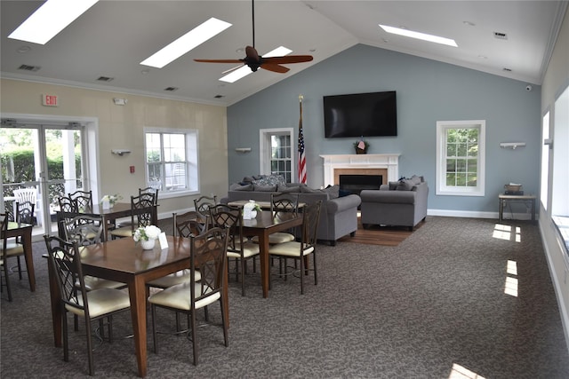 60 Erin Ln Unit 60, East Setauket, NY 11733 - carpeted dining area featuring a skylight, vaulted ceiling, a fireplace, a ceiling fan, and ornamental molding