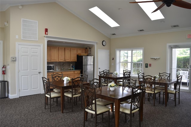60 Erin Ln Unit 60, East Setauket, NY 11733 - dining area featuring dark colored carpet, vaulted ceiling, a skylight, plenty of natural light, and ceiling fan