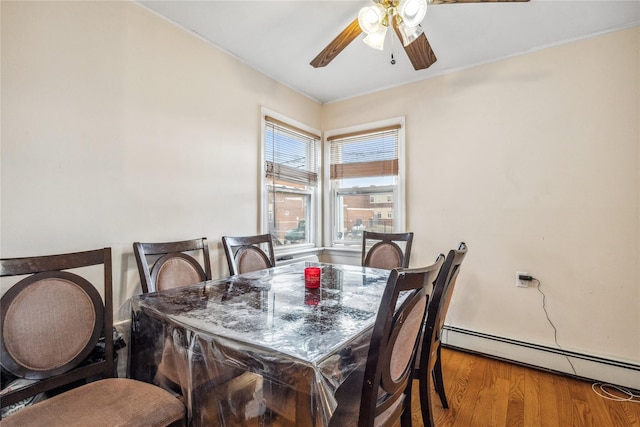 dining room with a baseboard radiator, wood finished floors, and a ceiling fan
