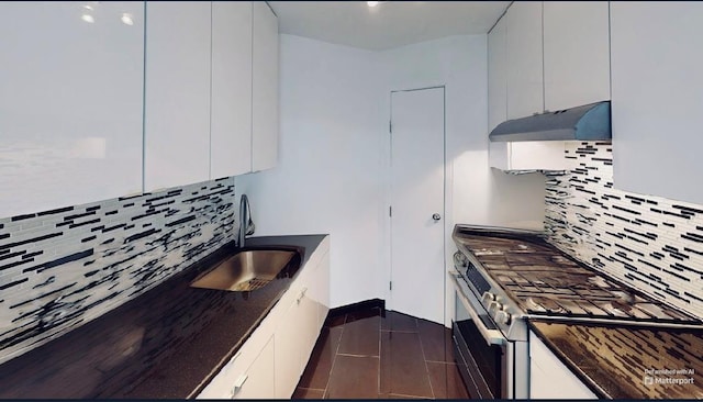 2 Bay Club Dr Unit 6Z4, Bayside, NY 11360 - kitchen with under cabinet range hood, stainless steel range with gas stovetop, dark countertops, tasteful backsplash, and white cabinets