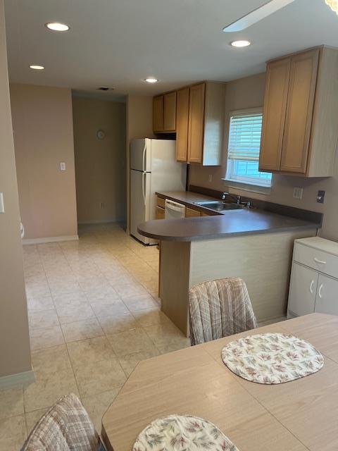 703 Pebble Beach Path, Riverhead, NY 11901 - kitchen featuring a sink, white appliances, baseboards, dark countertops, and recessed lighting