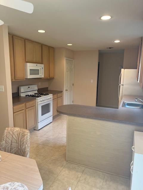703 Pebble Beach Path, Riverhead, NY 11901 - kitchen with white appliances, a peninsula, recessed lighting, a sink, and light tile patterned floors