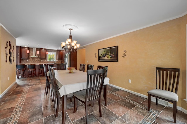 dining room featuring ornamental molding, baseboards, and an inviting chandelier