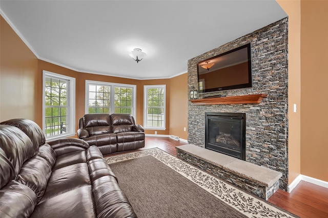 living area with baseboards, crown molding, and wood finished floors