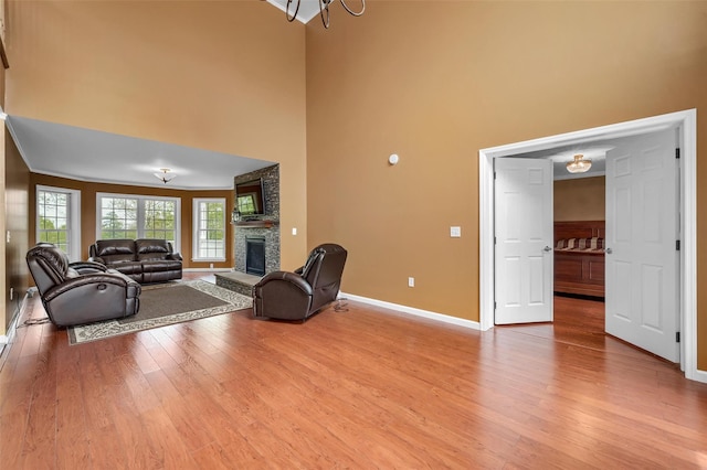 unfurnished living room with a high ceiling, light wood finished floors, and a fireplace