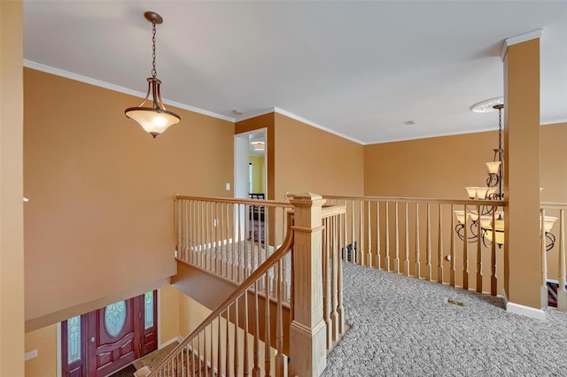 hallway with crown molding, carpet flooring, and an upstairs landing