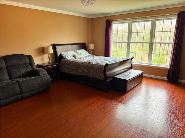 bedroom featuring wood finished floors, crown molding, baseboards, and multiple windows