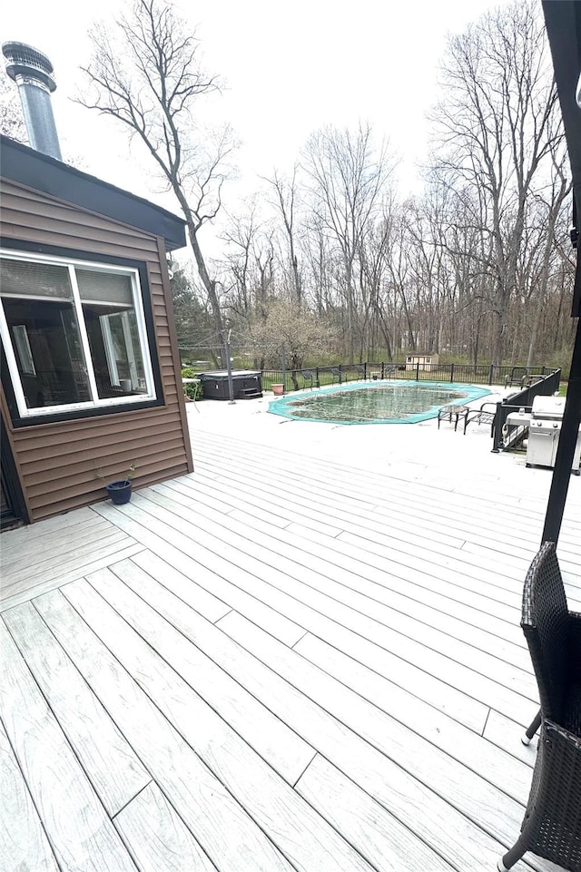 wooden deck featuring a fenced in pool