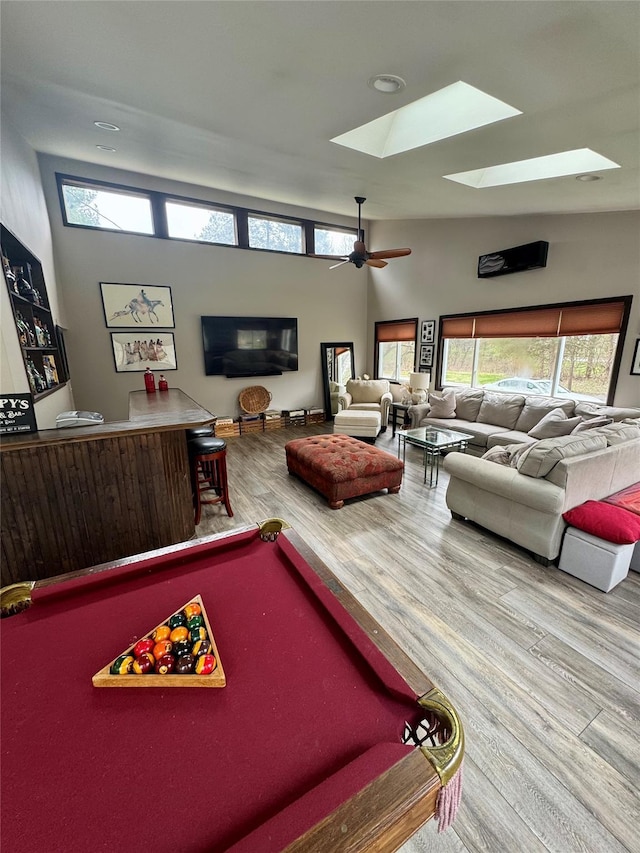 playroom with a wealth of natural light, wood finished floors, pool table, and a skylight