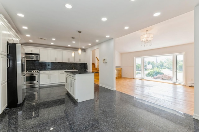 18 Oxford Rd, East Rockaway, NY 11518 - kitchen featuring stainless steel appliances, granite tiled floors, dark countertops, a center island, and recessed lighting