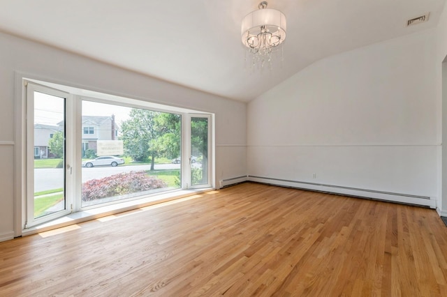 18 Oxford Rd, East Rockaway, NY 11518 - empty room featuring a baseboard radiator, vaulted ceiling, a chandelier, and light wood-type flooring