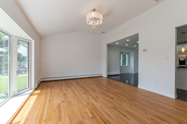 18 Oxford Rd, East Rockaway, NY 11518 - empty room featuring a baseboard heating unit, healthy amount of natural light, a chandelier, wood finished floors, and lofted ceiling