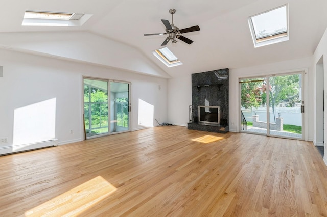 18 Oxford Rd, East Rockaway, NY 11518 - unfurnished living room featuring a skylight, a high end fireplace, light wood finished floors, lofted ceiling, and a baseboard radiator