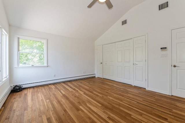 18 Oxford Rd, East Rockaway, NY 11518 - unfurnished bedroom with a baseboard heating unit, wood finished floors, high vaulted ceiling, a closet, and a ceiling fan