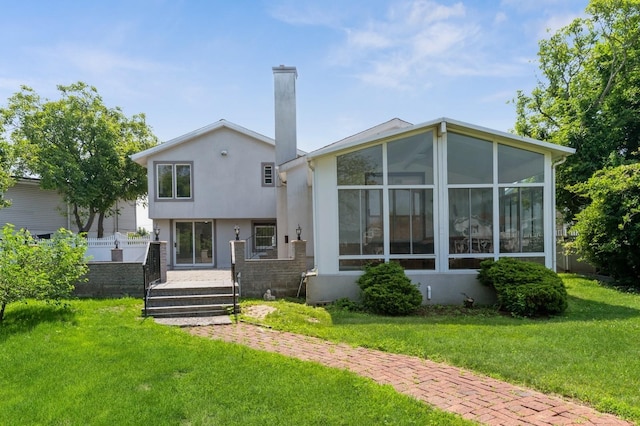 18 Oxford Rd, East Rockaway, NY 11518 - back of house featuring a sunroom, stucco siding, a lawn, and a chimney
