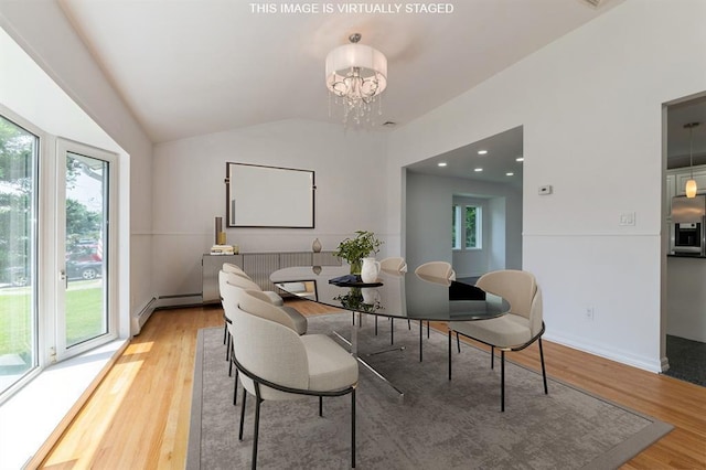 18 Oxford Rd, East Rockaway, NY 11518 - dining space with healthy amount of natural light, vaulted ceiling, light wood-style floors, a baseboard radiator, and a chandelier