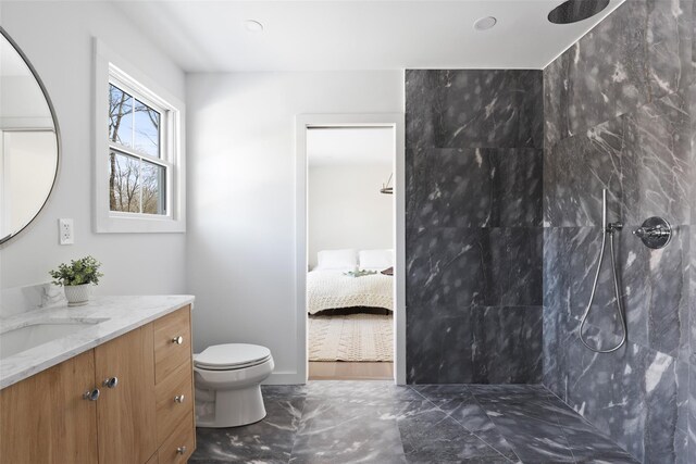 bathroom with connected bathroom, vanity, toilet, marble finish floor, and walk in shower