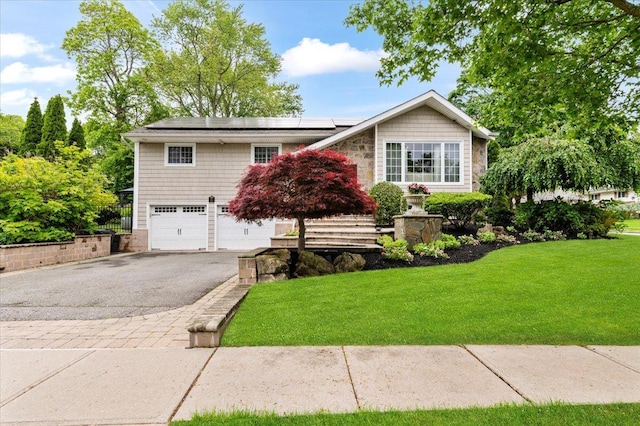 61 Beatrice Ln, Old Bethpage, NY 11804 - view of front facade with driveway, a garage, a front yard, and roof mounted solar panels