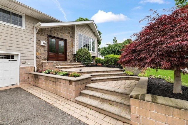61 Beatrice Ln, Old Bethpage, NY 11804 - property entrance featuring french doors, stone siding, and a garage