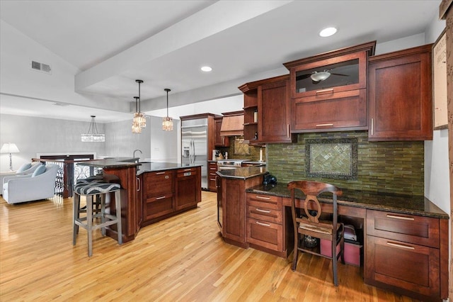 61 Beatrice Ln, Old Bethpage, NY 11804 - kitchen with dark countertops, light wood-style floors, built in refrigerator, a breakfast bar, and backsplash