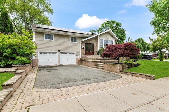 61 Beatrice Ln, Old Bethpage, NY 11804 - view of front of property featuring driveway, a garage, solar panels, a front lawn, and stone siding