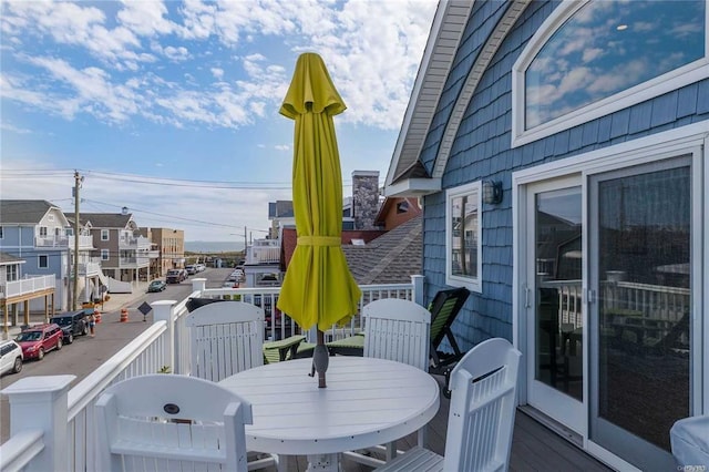 wooden terrace featuring outdoor dining area and a residential view
