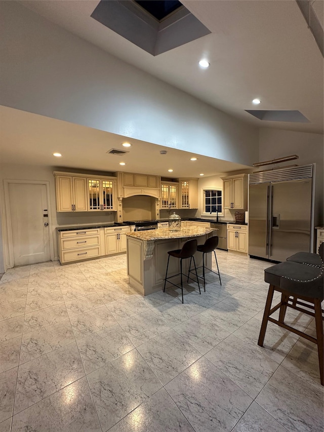 121 W Seaman Ave, Freeport, NY 11520 - kitchen featuring glass insert cabinets, a center island, a high ceiling, visible vents, and stainless steel appliances