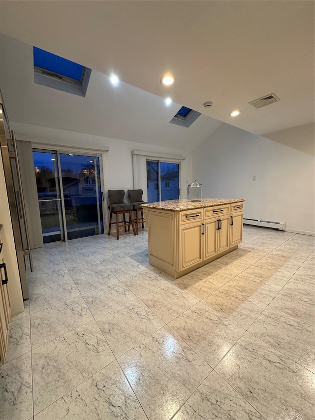 121 W Seaman Ave, Freeport, NY 11520 - kitchen featuring visible vents, a kitchen island with sink, light brown cabinetry, light stone countertops, and a baseboard heating unit