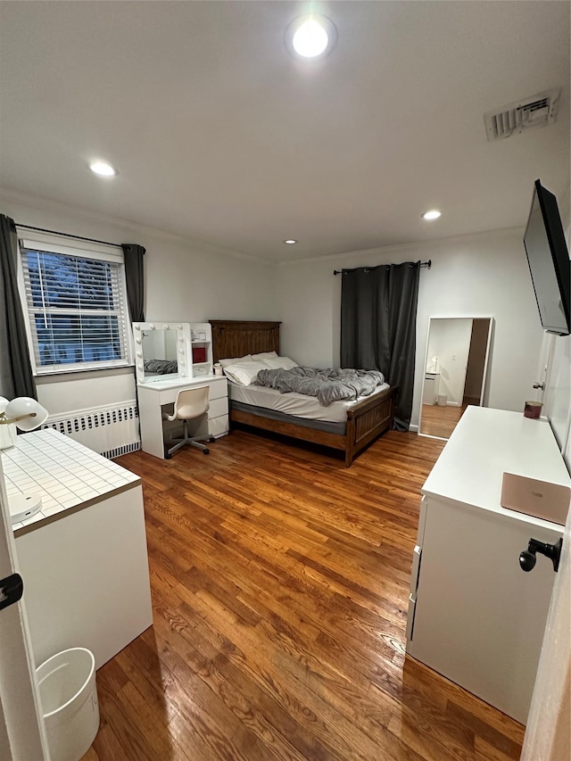 121 W Seaman Ave, Freeport, NY 11520 - bedroom with visible vents, radiator heating unit, recessed lighting, and wood finished floors