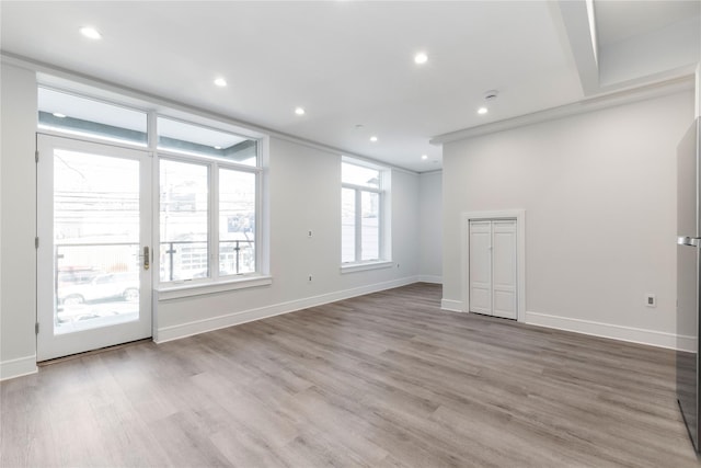 empty room with light wood finished floors, baseboards, and recessed lighting