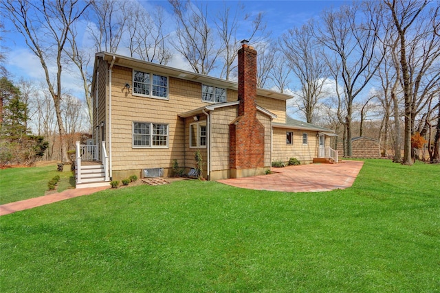 back of property with a yard, a patio, and a chimney