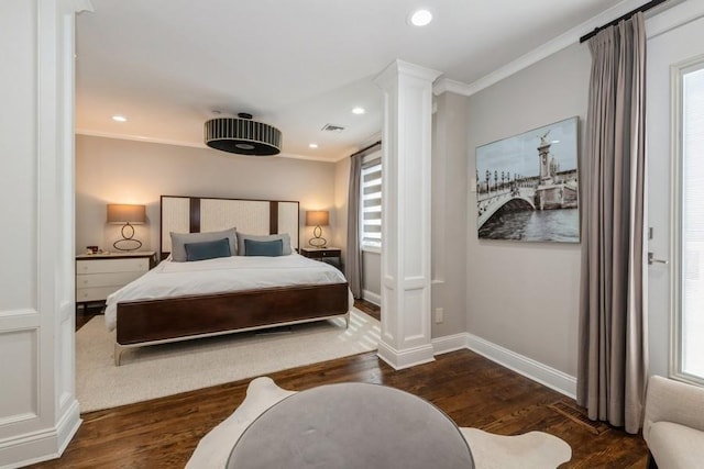 bedroom featuring ornamental molding, ornate columns, wood finished floors, and multiple windows