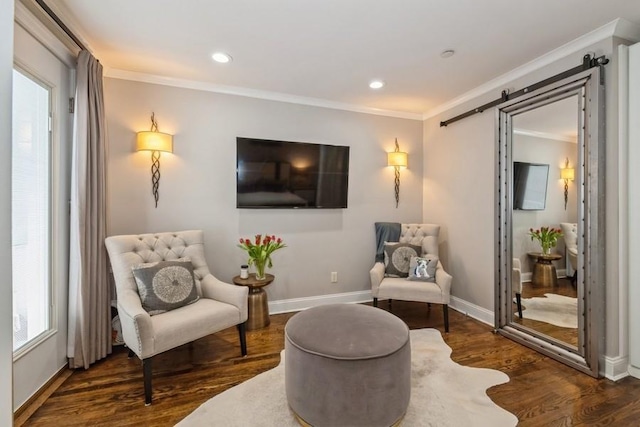 sitting room featuring baseboards, a barn door, ornamental molding, recessed lighting, and wood finished floors