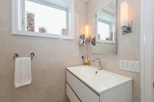 bathroom with vanity and tile walls
