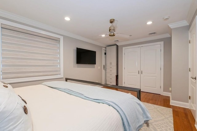 bedroom with a closet, baseboards, recessed lighting, visible vents, and wood finished floors