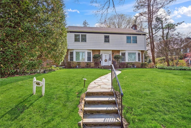 46 Wensley Dr, Great Neck, NY 11021 - colonial house featuring a chimney, a front lawn, and brick siding