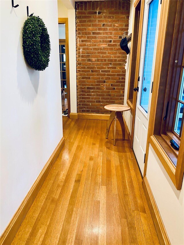 46 Wensley Dr, Great Neck, NY 11021 - hallway featuring baseboards, light wood-style floors, and brick wall